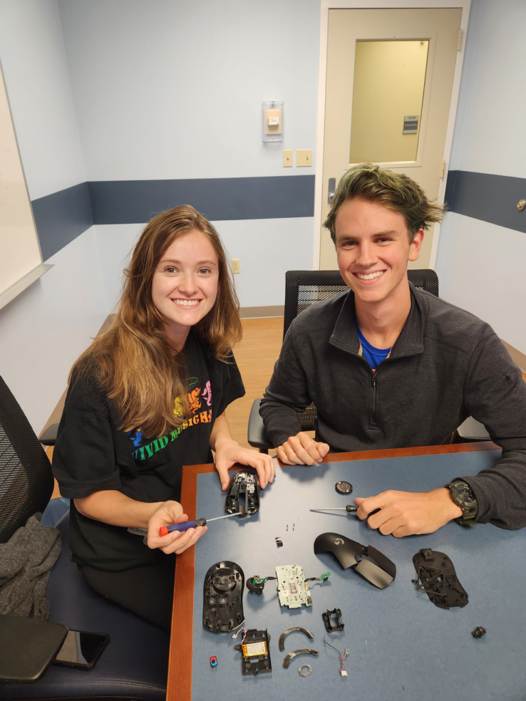 Portrait of a man and woman smiling in front of electrical appliances.